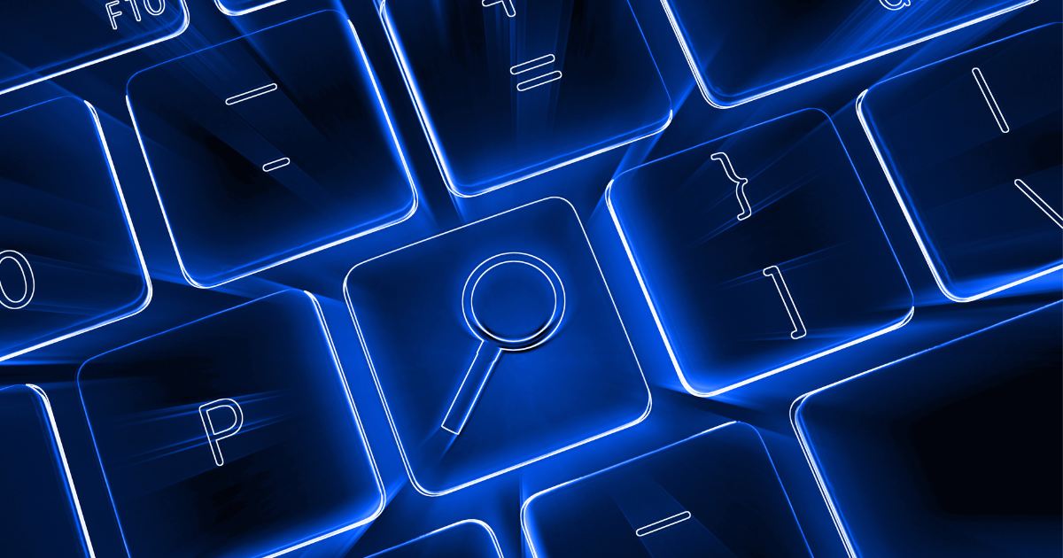 Teclado iluminado em azul com o ícone de uma lupa de busca em uma das teclas